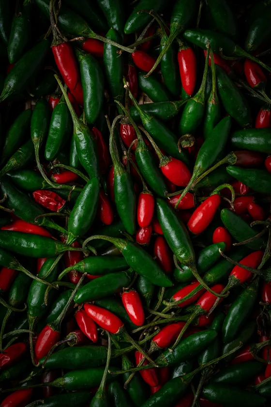 Pimientas pequeñas verdes y rojas amontonadas con sus rabos